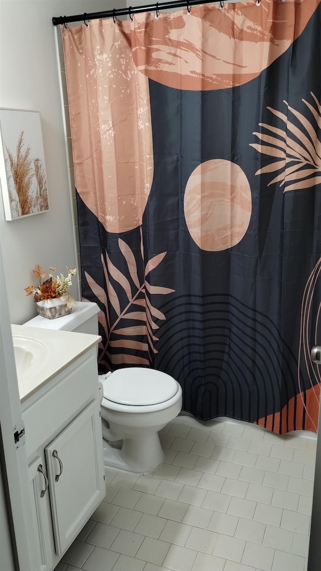 bathroom with tile patterned flooring, vanity, and toilet