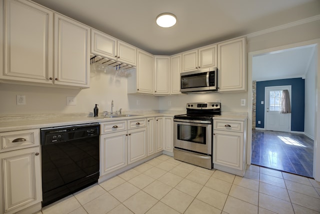 kitchen featuring white cabinets, crown molding, sink, light tile patterned floors, and appliances with stainless steel finishes