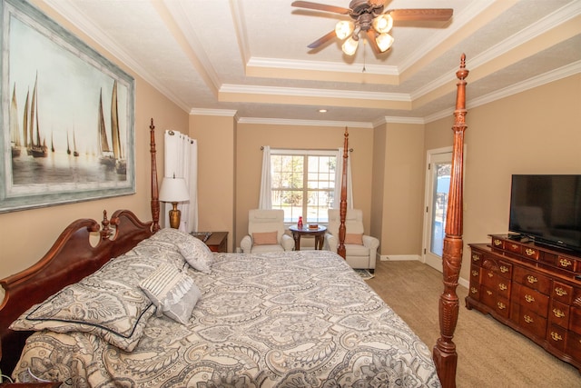 carpeted bedroom with ceiling fan, crown molding, and a tray ceiling