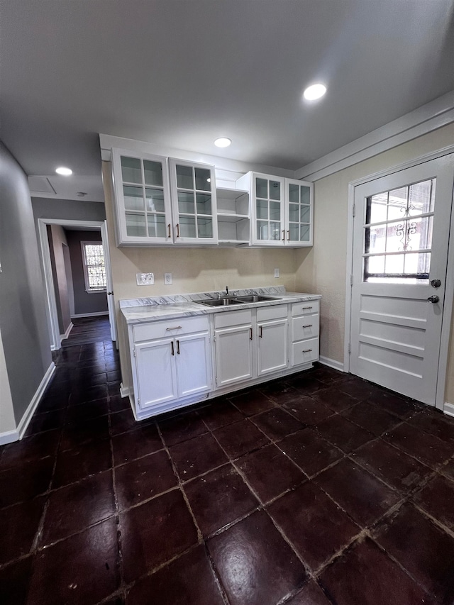 kitchen with white cabinets, dark tile patterned floors, and sink