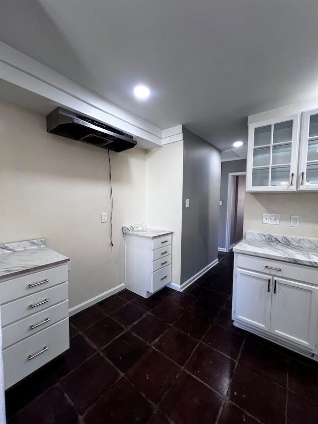 kitchen with white cabinets and dark tile patterned flooring