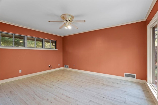 spare room with crown molding, a healthy amount of sunlight, and light wood-type flooring