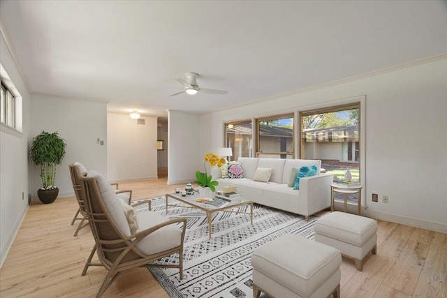 living room with ceiling fan, crown molding, and light wood-type flooring