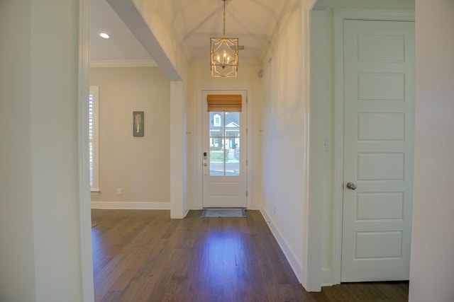 foyer entrance with dark hardwood / wood-style flooring, crown molding, and a chandelier