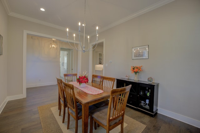 dining area with crown molding, dark wood-type flooring, and an inviting chandelier