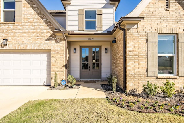 entrance to property with a garage and french doors