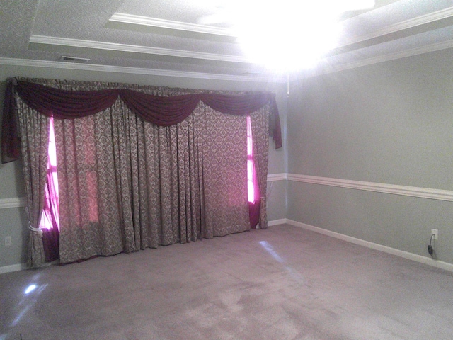 carpeted spare room featuring a textured ceiling, a tray ceiling, and crown molding