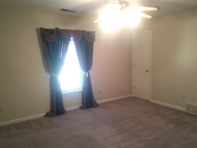 carpeted spare room with ceiling fan