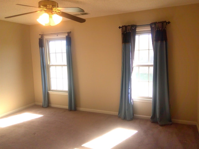 carpeted spare room with ceiling fan and a textured ceiling