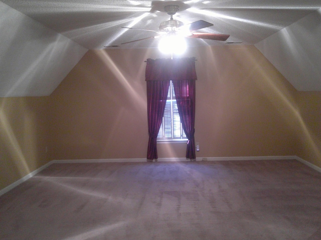 additional living space with ceiling fan, carpet floors, and vaulted ceiling