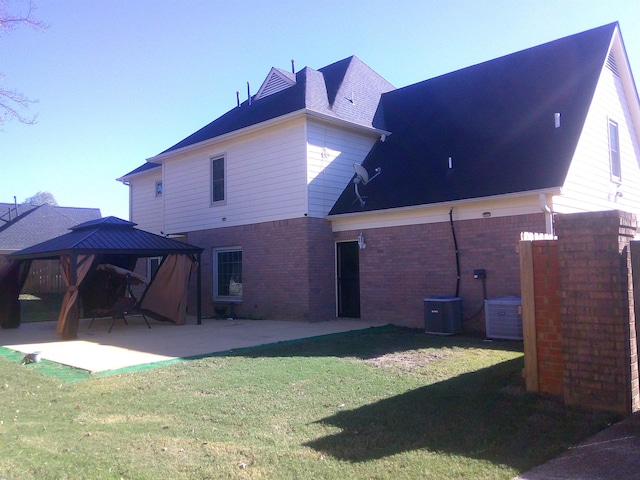 rear view of property with a gazebo, a yard, and a patio