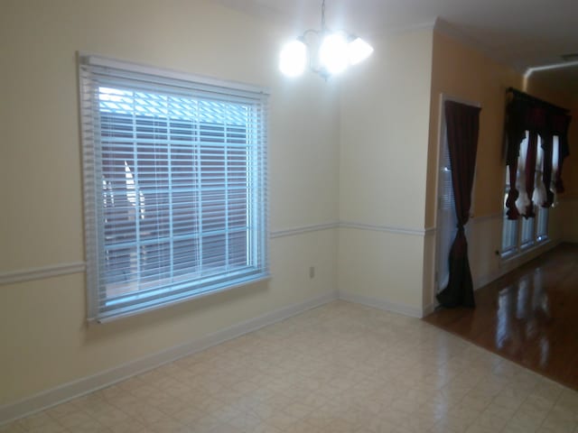 unfurnished room featuring an inviting chandelier