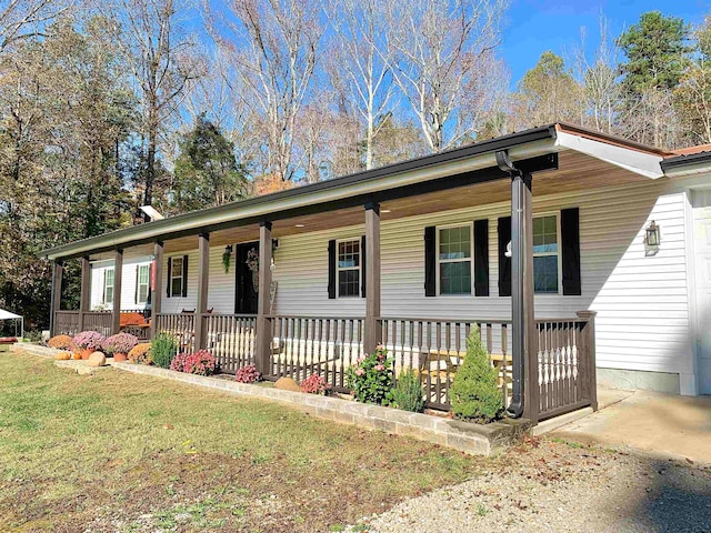 ranch-style house featuring a porch and a front lawn