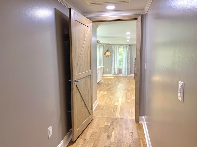 hall with crown molding and light hardwood / wood-style flooring