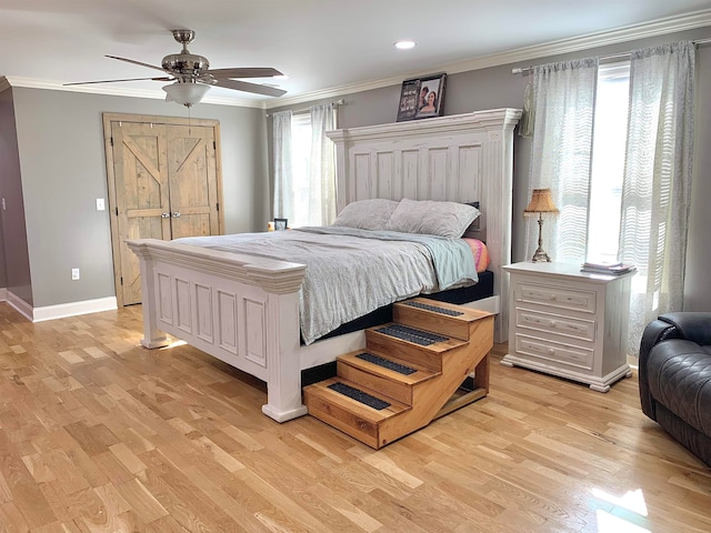 bedroom featuring multiple windows, ceiling fan, ornamental molding, and light wood-type flooring