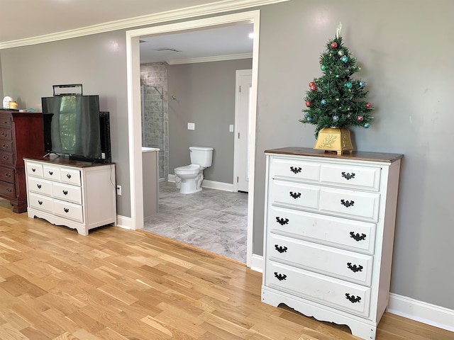 bathroom featuring a shower, hardwood / wood-style floors, toilet, and ornamental molding