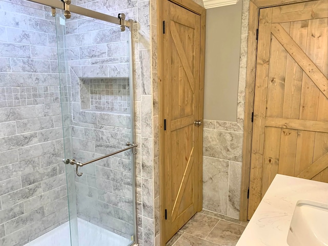 bathroom featuring a shower with door and sink