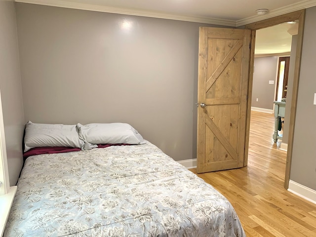 bedroom featuring ornamental molding and light hardwood / wood-style flooring