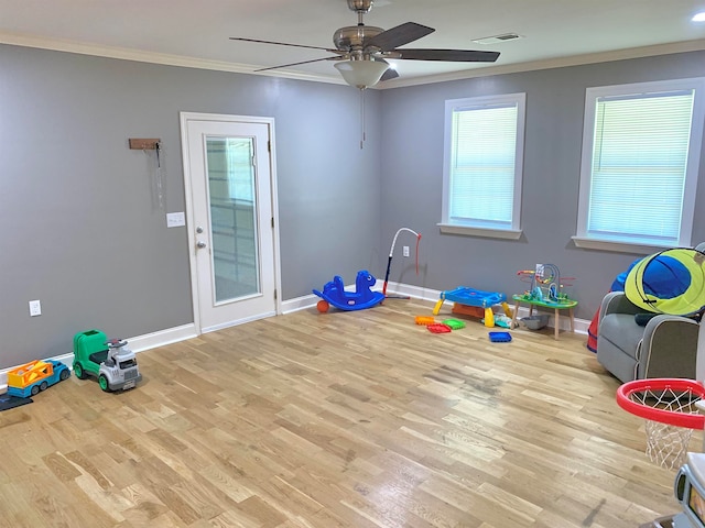 playroom featuring light hardwood / wood-style floors, ceiling fan, and ornamental molding