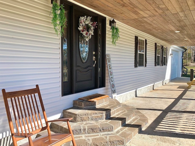 view of exterior entry featuring covered porch