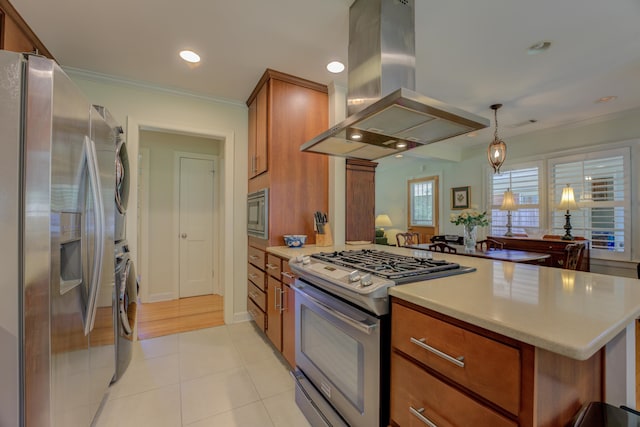 kitchen with island exhaust hood, stainless steel appliances, kitchen peninsula, and stacked washing maching and dryer