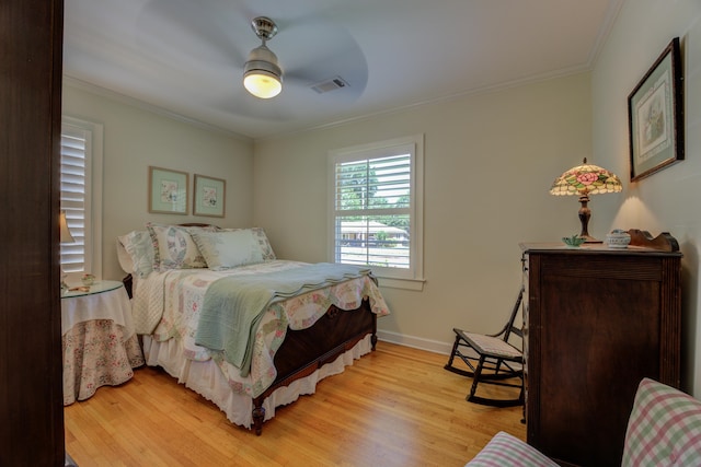 bedroom featuring light wood-type flooring, ceiling fan, and crown molding