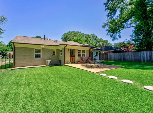 rear view of property featuring a patio area and a yard