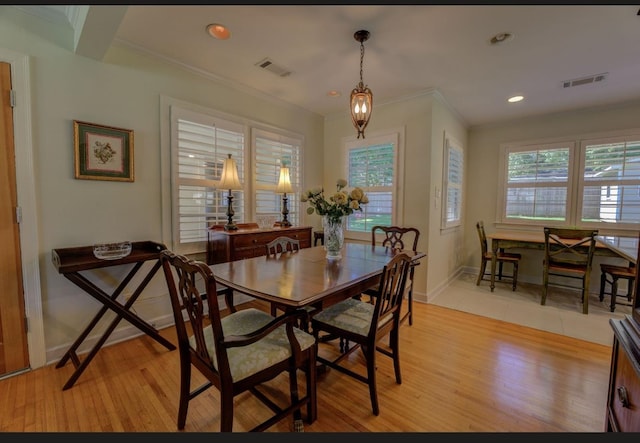 dining area with light hardwood / wood-style flooring, plenty of natural light, and ornamental molding