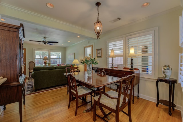 dining space with ceiling fan, crown molding, and light hardwood / wood-style floors