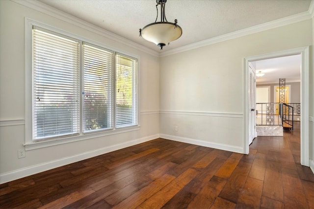 spare room featuring dark hardwood / wood-style flooring, ornamental molding, and a textured ceiling