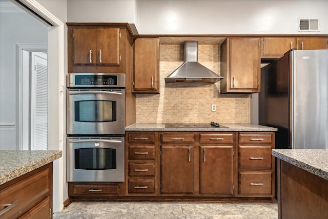 kitchen featuring backsplash, stainless steel appliances, and wall chimney exhaust hood