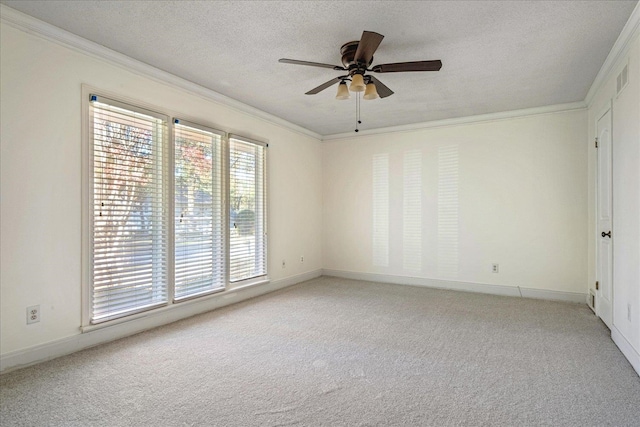 carpeted spare room featuring ceiling fan, ornamental molding, and a textured ceiling