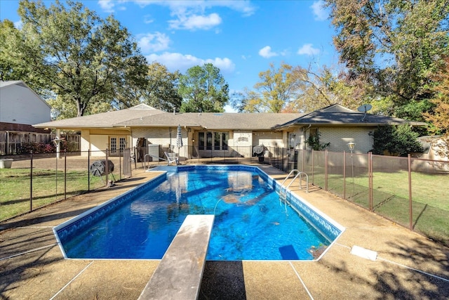 view of swimming pool with a lawn, a diving board, a patio, and french doors