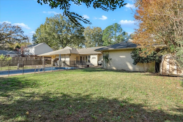 rear view of property with a yard and a fenced in pool