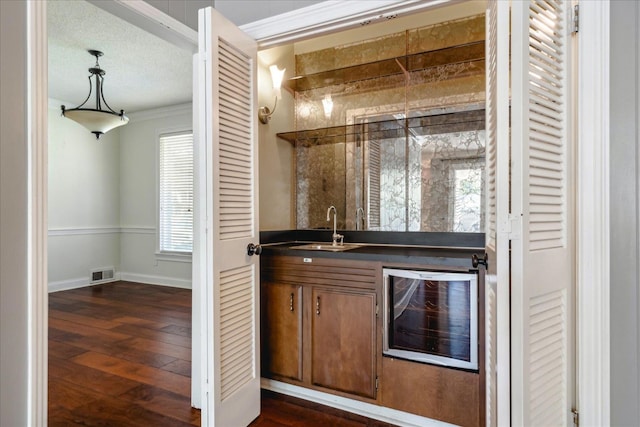 bar featuring a textured ceiling, dark hardwood / wood-style floors, wine cooler, and sink