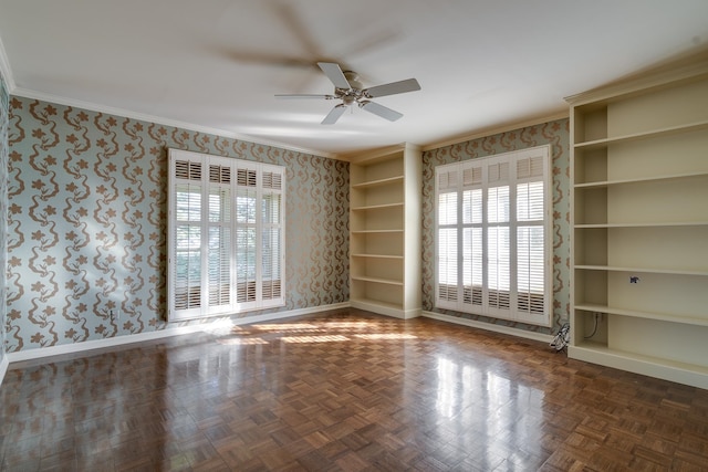 spare room featuring dark parquet flooring, ceiling fan, and ornamental molding