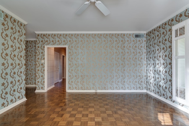 spare room featuring dark parquet flooring, ceiling fan, and crown molding