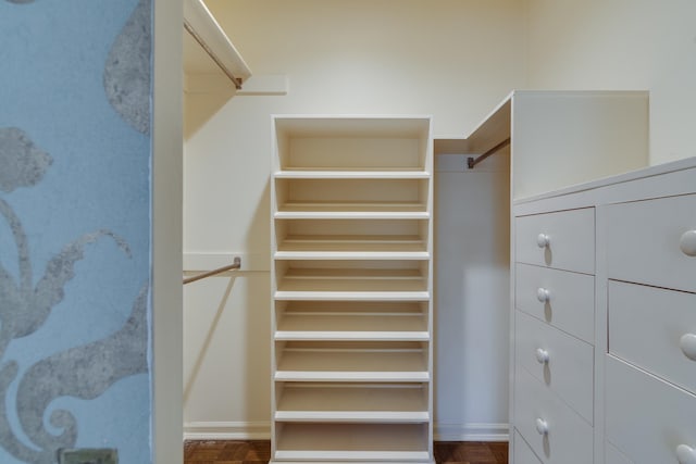 spacious closet with dark hardwood / wood-style flooring