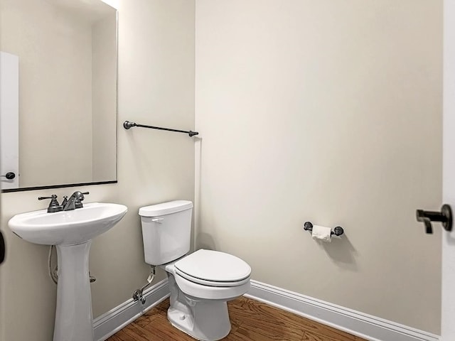 bathroom with sink, hardwood / wood-style floors, and toilet