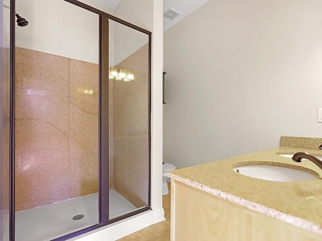 bathroom with tile patterned flooring, vanity, toilet, and a shower with shower door