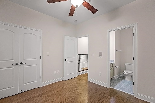 bedroom featuring hardwood / wood-style floors, a closet, ceiling fan, and ensuite bathroom