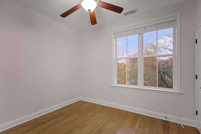 empty room with hardwood / wood-style floors and ceiling fan