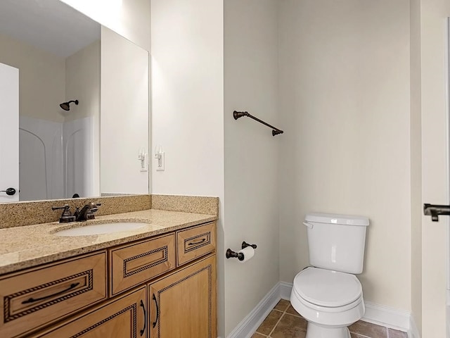 bathroom with toilet, a shower, vanity, and tile patterned floors