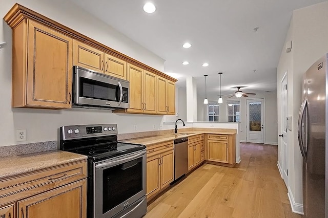 kitchen featuring light hardwood / wood-style flooring, ceiling fan, appliances with stainless steel finishes, decorative light fixtures, and kitchen peninsula