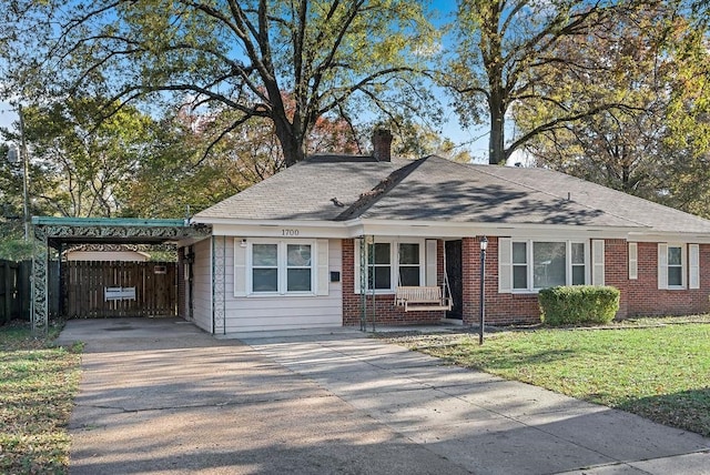 view of front of house with a front lawn, a porch, and a carport