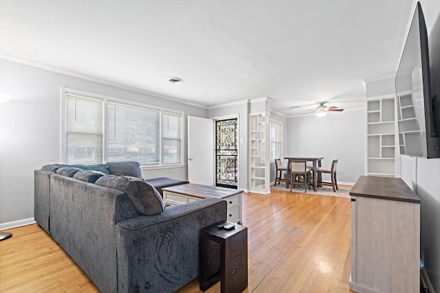 living room with hardwood / wood-style flooring, ceiling fan, and crown molding