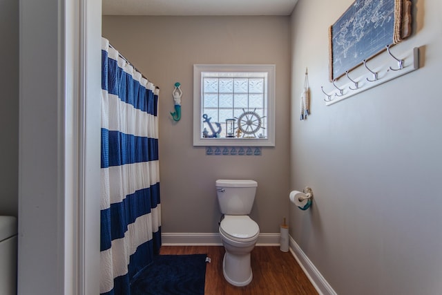 bathroom with hardwood / wood-style flooring, toilet, and walk in shower