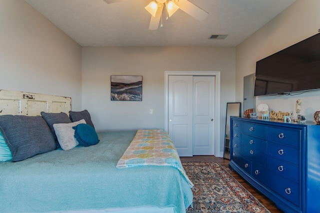 bedroom with a closet, dark wood-type flooring, and ceiling fan