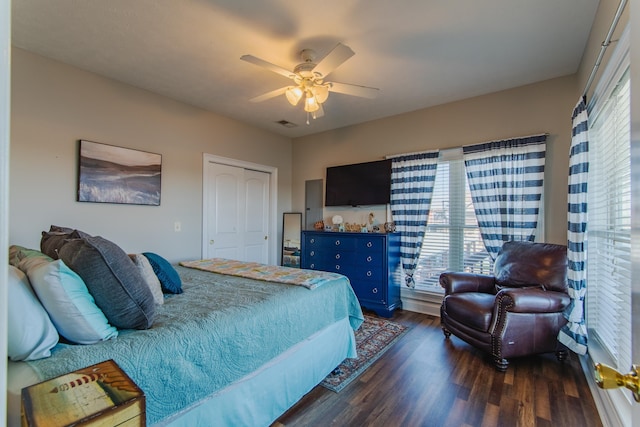 bedroom featuring ceiling fan, a closet, dark hardwood / wood-style flooring, and multiple windows