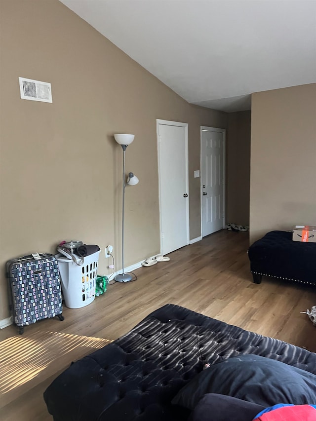 sitting room featuring hardwood / wood-style floors and lofted ceiling